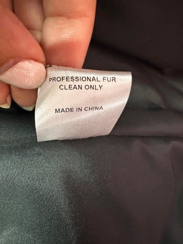 A label on the inside of a coat stating that it is professional fur