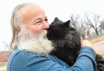 Ingemar Woods holding and kissing a cat