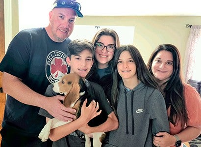 Ollie the beagle with his new family.