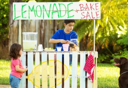 Children and dog running a lemonade stand and bake sale.