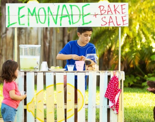 Children and dog running a lemonade stand and bake sale.